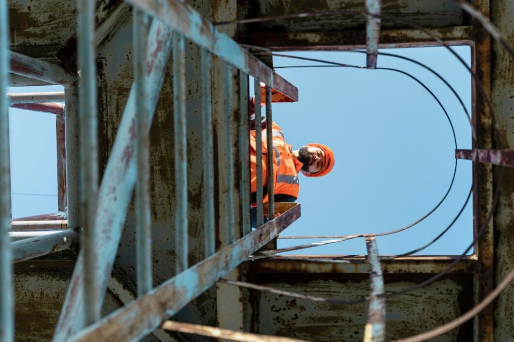 Safety worker inspecting industrial equipment from above